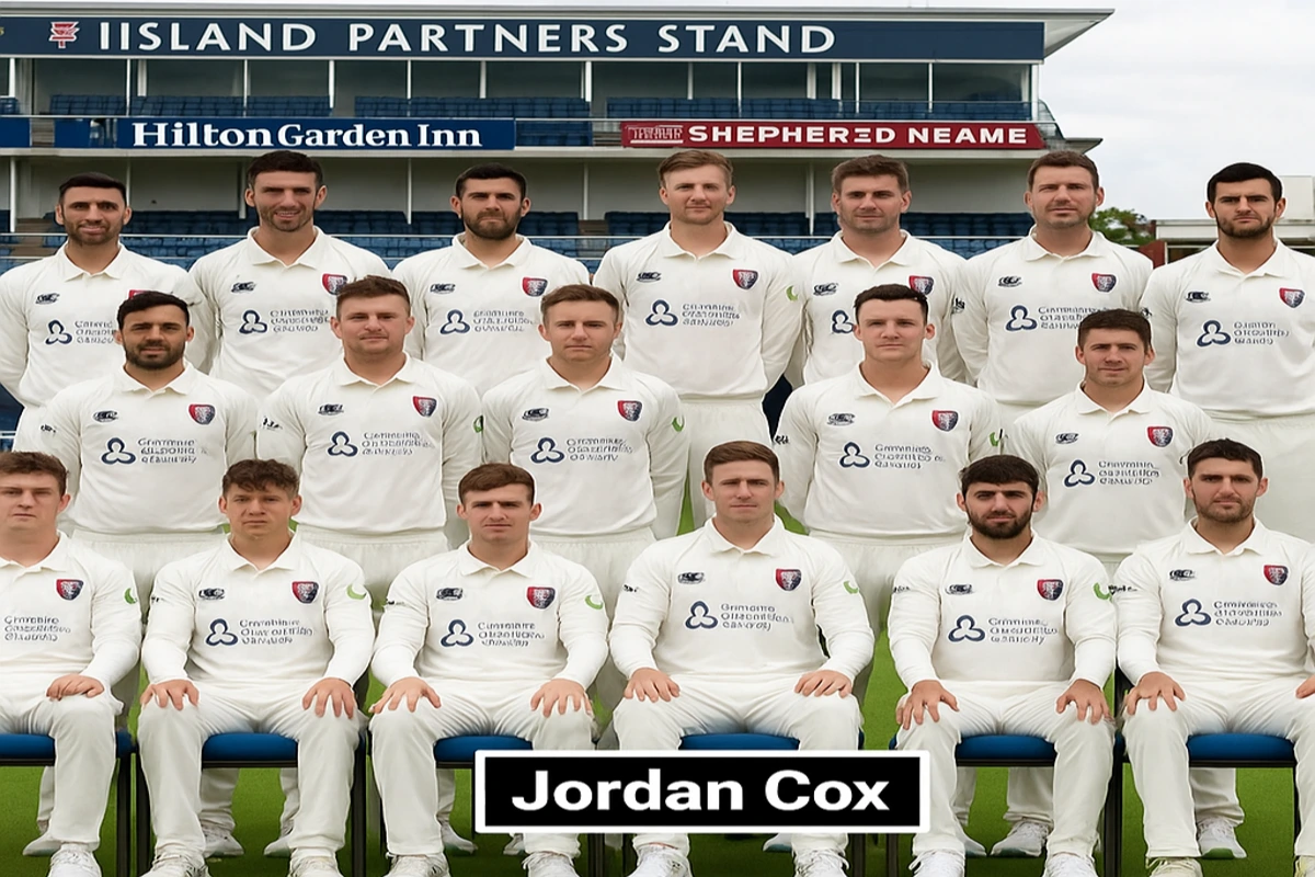 Jordan Cox batting during a County Championship match in 2025, wearing Kent kit and focused on a red cricket ball.